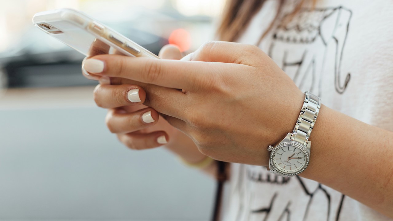 Close-up of a woman holding a smartphone in her hands to symbolize digital health applications for mobiles